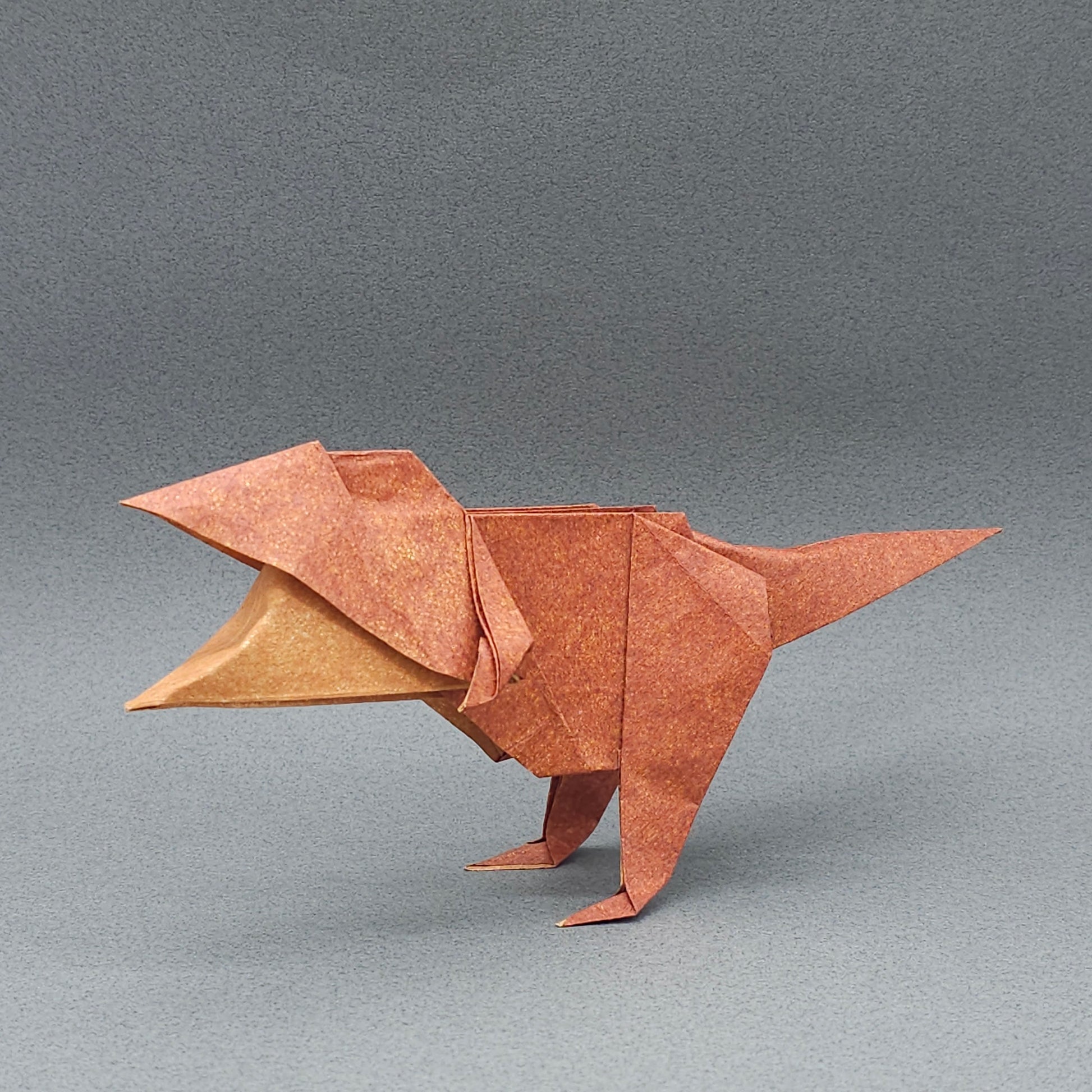 Baby Tyrannosaurus origami on a gray background